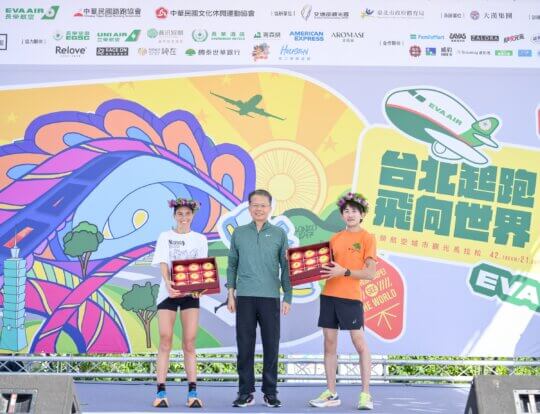 EVA Air marathon winners Eve Mure and Suzuki Satoru on stage with EVA Air President Sun Chia-ming